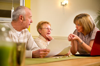 Daughter discussing paperwork with elderly parents